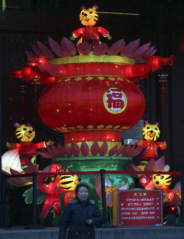 A woman walks past a giant lantern at the Confucian Temple in Nanjing, Jiangsu Province, Feb. 11, 2010. The 2010 Jiangsu Qinhuai Lantern Fair also known as the 24th Confucian Temple Spring Festival Lantern Fair, kicked off in Nanjing on Thursday.