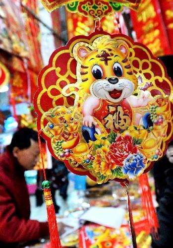 Citizens pick up tiger ornaments at a market in Yinchuan, capital of north China's Ningxia Hui Autonomous Region, Feb. 12, 2010, during the preparation for the Spring Festival which falls on Feb. 14. [Liu Quanlong/Xinhua]