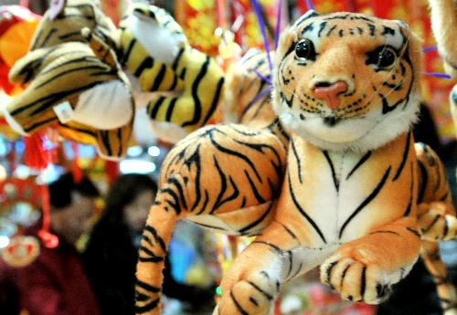 Tiger toys are seen as citizens pick up tiger ornaments at a market in Yinchuan, capital of north China's Ningxia Hui Autonomous Region, Feb. 12, 2010, during the preparation for the Spring Festival which falls on Feb. 14. [Liu Quanlong/Xinhua]