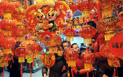 Citizens pick up tiger ornaments at a market in Yinchuan, capital of north China's Ningxia Hui Autonomous Region, Feb. 12, 2010, during the preparation for the Spring Festival which falls on Feb. 14. [Liu Quanlong/Xinhua]