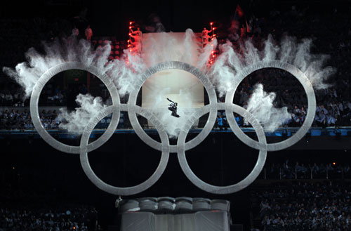 A snowboard athlete jumps over the Olympic rings on the opening ceremony for the 2010 Winter Olympic Games inside the BC Place stadium in Vancouver, Canada on Feb. 12, 2010. [Yang Lei/Xinhua]
