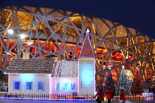 People walk past decorative landscapes in front of the National Stadium, also known as the 'Bird's Nest', in Beijing, capital of China, Feb. 12, 2010. [Wang Huaigui/Xinhua]