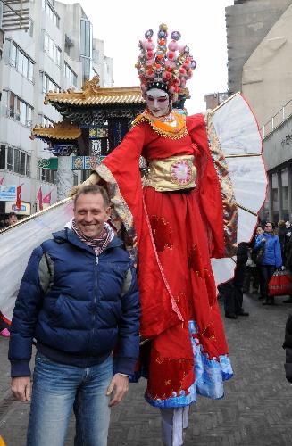 A Dutch man poses for a picture with a stilt performer during a celebration for the Chinese Spring Festival, or lunar New Year, in the Hague of the Netherlands, on Feb. 13, 2010. (Xinhua/Wang Xiaojun)