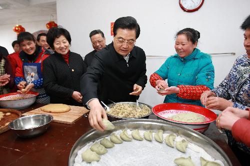 Chinese President Hu Jintao prepares special local New Year food with family members of Zhang Tangmei at Wulong Village in Gutian Town of Shanghang County under Longyan City, southeast China's Fujian Province, February 13, 2010.