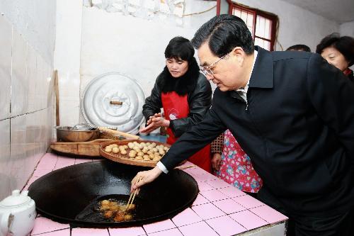 Chinese President Hu Jintao prepares special local New Year food with family members of Zhang Tangmei at Wulong Village in Gutian Town of Shanghang County under Longyan City, southeast China's Fujian Province, February 13, 2010.