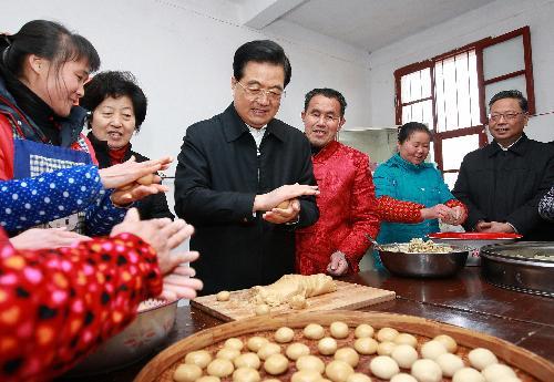 Chinese President Hu Jintao prepares special local New Year food with family members of Zhang Tangmei at Wulong Village in Gutian Town of Shanghang County under Longyan City, southeast China's Fujian Province, February 13, 2010. 