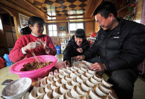  Sailor Liu Taixin (R) and his family members make dumplings on a coal carrier in the Zaozhuang section of the Beijing-Hangzhou Grand Canal in Zaozhuang, east China's Shandong Province, February 13, 2010. 