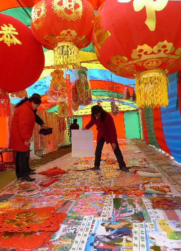 People select Spring Festival decorations on a street in Dafeng, east China's Jiangsu Province, February 12, 2010. 