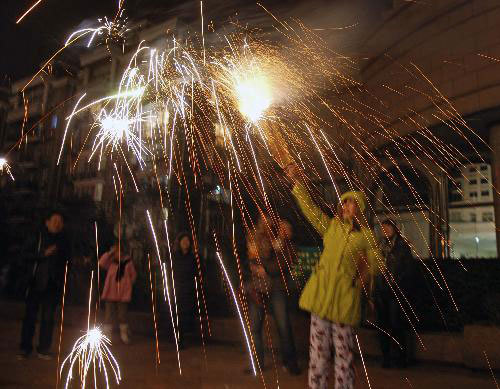 People explode fireworks to celebrate the Spring Festival on a street in Hangzhou, capital of east China's Zhejiang Province, February 13, 2010.