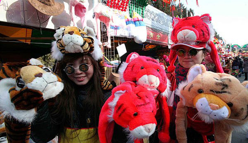 People stroll around the Ditan Park Temple Fair on February 13, 2010, the Chinese lunar New Year's eve. Ditan Park, or Temple of Earth, annually holds Beijing's most popular temple fair, usually featured with the traditional food and folk art works.