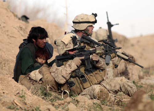 U.S. Marines from Bravo Company, 1st Battalion, 6th Marines, protect an Afghan man and his child after Taliban fighters opened fire in the town of Marjah, in Nad Ali district, Helmand province, February 13, 2010. (Xinhua/Reuters photo)