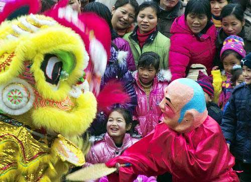 People watch lion dance performance on a street in Guilin, southwest China's Guangxi Zhuang Autonomous Region, Feb. 14, 2010. Folk performance celebrating the Spring Festival attracted many local residents on Sunday. (Xinhua/Li Caijia)