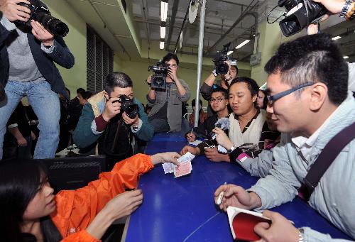 Li Jiangang (2nd R), the first passenger with real-name ticket of China, gets his ticket in Guangzhou, capital of south China's Guangdong Province, Jan. 21, 2010. Southern Guangdong Province launched the pilot real-name ticket system Thursday morning amid China's efforts to curb ticket hoarding by scalpers. 