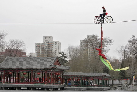 A Chinese acrobat rides a bicycle on a tightrope during a show at a temple fair celebrating Chinese New Year in Beijing.[