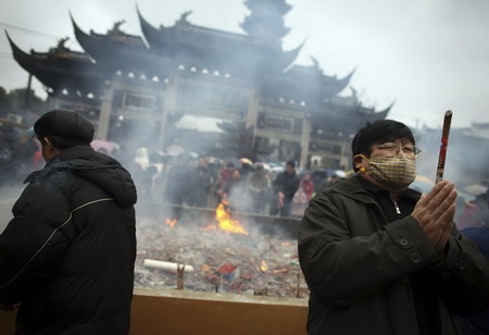 Worshippers offer incense as they visit the Longhua temple in Shanghai on the first day of the Chinese New Year.[