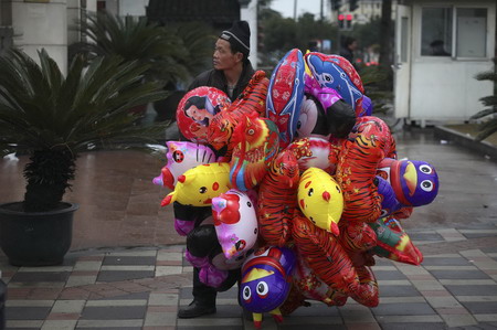A balloon seller waits for customers outside Longhua temple in Shanghai on the first day of the Chinese New Year February 14, 2010. The Chinese New Year began on Sunday and according to the Lunar calendar, it is the Year of the Tiger.[