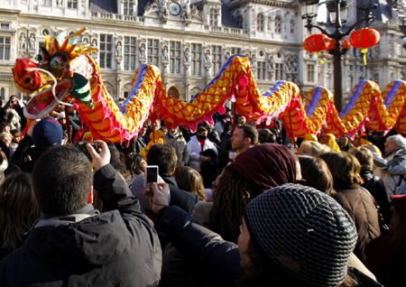 People take photos of the dragon dance to celebrate the Chinese New Year in Paris, February 14, 2010. [Photo/Xinhua]
