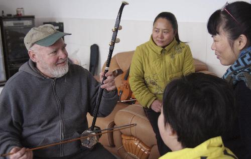 David from the U.S. plays 'erhu', a traditional Chinese two-string instrument, during a Spring Festival family party in Rongshui Miao Autonomous County, southwest China's Guangxi Zhuang Autonomous Region, Feb. 13, 2010. David spent the eve of the Chinese Spring Festival, or lunar New Year, at his Chinese father-in-law's home in Rongshui, enjoying the Chinese traditional family reunion pleasure.