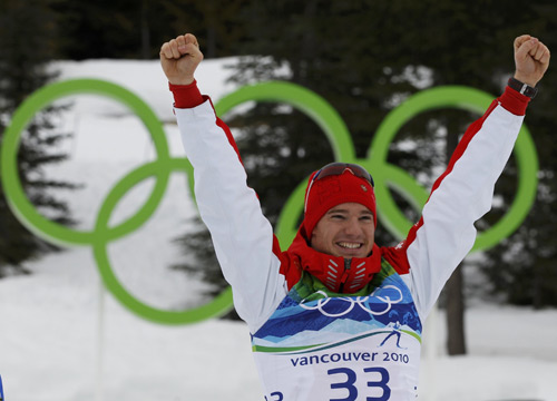 Switzerland's Dario Cologna celebrates during the flower ceremony after winning gold in the men's 15 km individual start cross-country final at the Vancouver Winter Olympic Games in Whistler, British Columbia February 15, 2010.