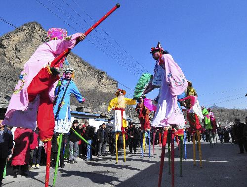Folk artists perform on stilts at Hebei village in suburbs of Beijing, capital of China, Feb. 15, 2010. Local people have had traditions of performing stilt walks during the Spring Festival to celebrate the Chinese Lunar New Year for more than 160 years in Hebei village.