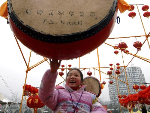 A girl plays a big drum at Huiyuan Garden in Hefei city, capital of east China's Anhui Province, Feb. 15, 2010. Lots of citizens went to Huiyuan Garden, where people could attend the temple fair, to enjoy various folk artistic performance and delicious food, and celebrate the Chinese Lunar New Year of Tiger.