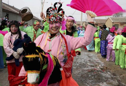 Folk perfomers from Wanghong village perform Yangge (a popular rural folk dance) at Lijiadian village of Ninghe County in north China's Tianjin, Feb. 16, 2010.