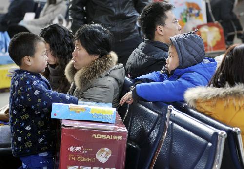 People wait for their buses at a long-distance bus station in Jinan, capital of east China's Shandong Province, Feb. 17, 2010. Jinan met its medium and short-distance Spring Festival travel peak on Wednesday with most of the travelers going by long-distance buses to visit their relatives. [Zhu Zheng/Xinhua]