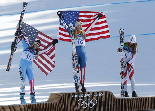 Lindsey Vonn (C) of the U.S. celebrates winning the gold medal on the podium together with silver medalist Julia Mancuso (L) and Austria's bronze medalist Elisabeth Goergl following the women's Alpine Skiing Downhill race at the Vancouver 2010 Winter Olympics in Whistler, British Columbia, February 17, 2010.