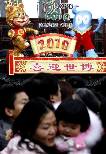 A tiger-shaped mascot and the mascot of the upcoming 2010 Shanghai World Expo 'Haibao' are seen above as people visit the Yu Garden, one of the most famous scenic spots in Shanghai, Feb. 17, 2010. The lantern festival held here has attracted a large number of visitors during the Spring Festival holidays.