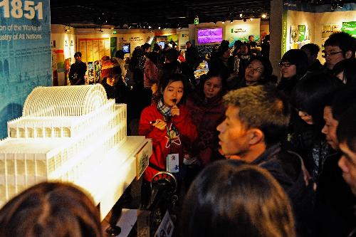 A volunteer introduces the planning of the 2010 Shanghai Expo to visitors at the Expo Exhibition Center in Shanghai, east China, Feb. 16, 2010. The Expo Exhibition Center attracted many citizens and tourists during the Spring Festival holidays.