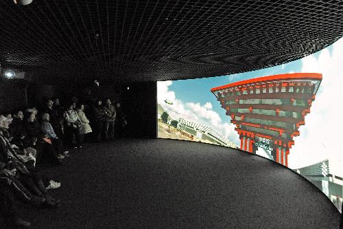 Visitors watch a promotion video of the 2010 Shanghai Expo at the Expo Exhibition Center in Shanghai, east China, Feb. 16, 2010. The Expo Exhibition Center attracted many citizens and tourists during the Spring Festival holidays.