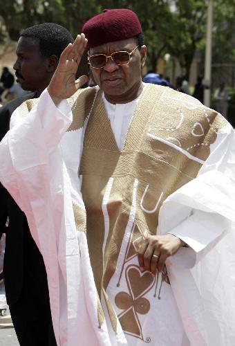 Niger's President Mamadou Tandja (R) waves upon his arrival to welcome France's President Nicolas Sarkozy at Diori Hamari airport in Niamey March 27, 2009. 