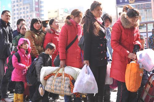 Passengers queue up to enter the Zhengzhou Railway Station in Zhengzhou, capital of Henan Province, Feb. 18, 2010. As the Spring Festival holiday is coming to an end, the railway system throughout China will meet a travel peak in the next two days as a large number of travellers start their journey back to their workplaces. 