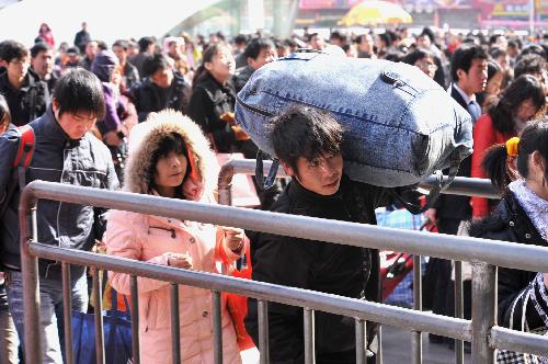 Passengers queue up to enter the Zhengzhou Railway Station in Zhengzhou, Henan Province, Feb. 18, 2010. As the Spring Festival holiday is coming to an end, the railway system throughout China will meet a travel peak in the next two days as a large number of travellers start their journey back to their workplaces. 