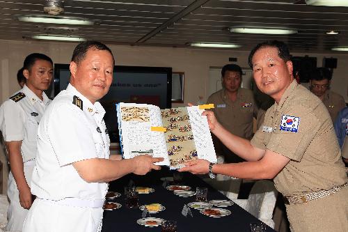 Qiu Yanpeng (L), commander of the Chinese naval escort flotilla in the Gulf of Aden, meets with Captain Kim Myung Sung, commander of the South Korean naval escort flotilla, on South Korea's destroyer 'Chungmugong Yi Sunshin', Feb. 18, 2010. 