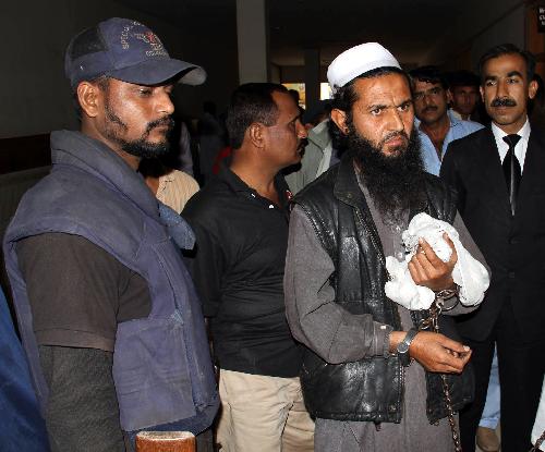 Alleged Taliban commander Abdullah (R Front), who goes by the alias Abu Waqas, is flanked by security officials as he appears at a court in Karachi, Pakistan, Feb. 18, 2010. According to police officials, Abdullah was involved in recruiting female suicide bombers and was arrested in Karachi while planning terrorist activities in the city.