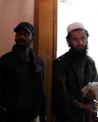 Alleged Taliban commander Abdullah (R), who goes by the alias Abu Waqas, is flanked by security officials as he appears at a court in Karachi, Pakistan, Feb. 18, 2010. According to police officials, Abdullah was involved in recruiting female suicide bombers and was arrested in Karachi while planning terrorist activities in the city. 