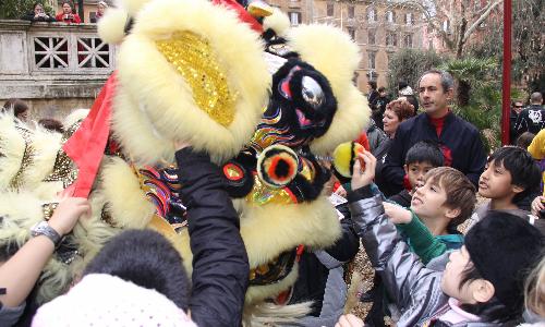 Students play with a 'lion' before a parade celebrating the Chinese Spring Festival in Rome, Italy, Feb. 18, 2010. Chinese traditonal dragon dance and lion dance performed by Italian students won great popularity among the Italians. Many overseas Chinese and local residents attended the parade on Feb. 18. 