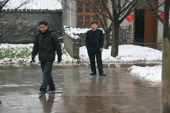 The abrupt snow wet the town&apos;s roads, but it did not stop the villagers going to greet their neighbors. [Elaine Duan/China.org.cn] 