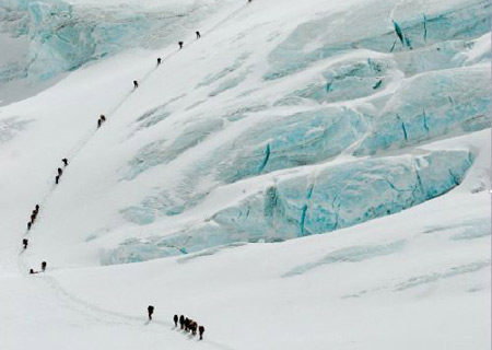 Photo shows some athletes climbing a snow-covered mountain in Tibet. (Photo: 51tibettour.com) 