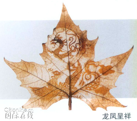 A leaf-carving work by Huang Taisheng of a dragon and phoenix.