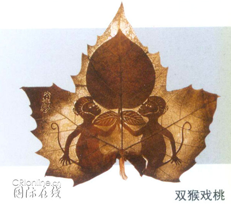 A leaf-carving work by Huang Taisheng of two monkeys fighting over a peach.