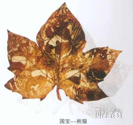 A leaf-carving picture by Huang Taisheng of pandas.