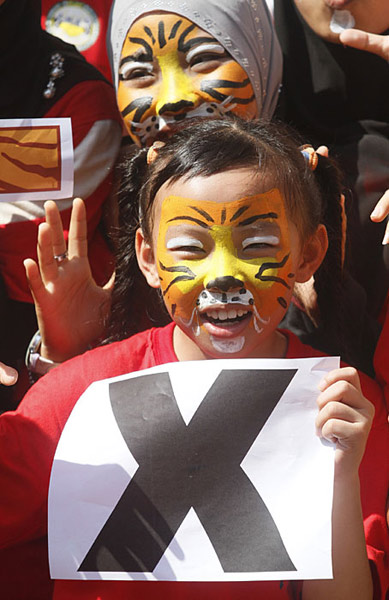 Volunteers with tiger-painted faces pose during the Tx2 Tiger Conservation Campaign Face Painting in conjunction with the Chinese Lunar New Year of the Tiger at Fo Guang Shan Dong Zen Buddhist Temple in Jenjarom, 100 kilometers (61 miles) west of Kuala Lumpur, Malaysia, Saturday, Feb. 20, 2010. The campaign which aims to help double the number of wild tigers in Malaysia by the next Year of the Tiger (2022), was launched by WWF- Malaysia. [Xinhua/AFP]