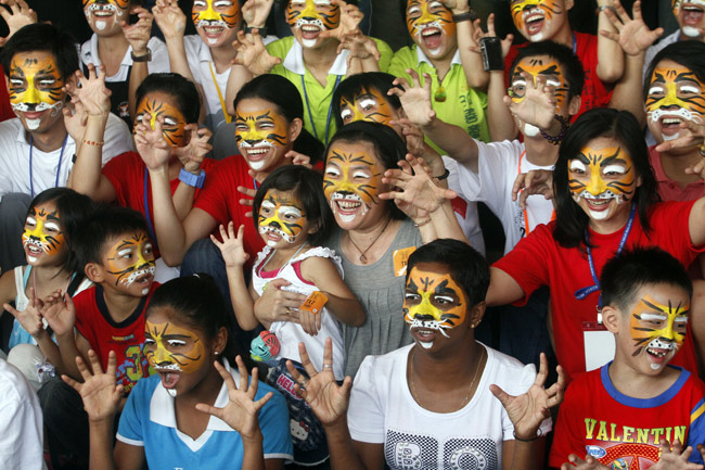 Teenagers with makeup of tiger pose for photo during the &apos;1,000 faces for 1,000 tigers&apos; campaign in Jenjarom town of Malaysia, Feb. 20, 2010. WWF-Malaysia launched the tiger conservation campaign on Saturday in conjunction with the Chinese Year of the Tiger. [Xinhua]