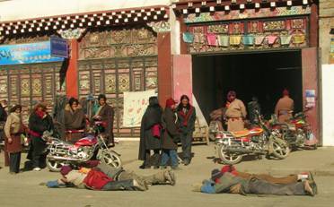 Pilgrims prostrate themselves on the way to Tagong Temple.