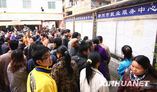 Migrant workers look at an information bulletin at a job fair in Liuzhou, Guangxi Zhuang Autonomous Region, on Feb. 20, 2010. Migrant workers went to the job fair for job opportunities on Friday after spending the Spring Festival holidays in their hometowns. 