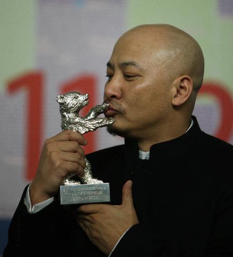 Wang Quan'an, director of Chinese film 'Tuan Yuan' (Apart Together), kisses the Silver Bear award for the best screenplay during a press conference following the awards ceremony of the 60th Berlinale International Film Festival in Berlin, capital of Germany, Feb. 20, 2010.