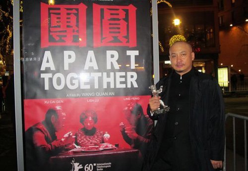 Wang Quan'an, director of Chinese film Tuan Yuan (Apart Together), kisses the Silver Bear award for the best screenplay during a press conference following the awards ceremony of the 60th Berlinale International Film Festival in Berlin, capital of Germany, Feb. 20, 2010. [Xinhua]