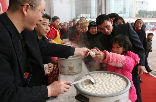 A girl receives free Tangyuan, or stuffed dumplings, at the Chengdu Lantern Festival Trade Fair in Chengdu, capital of southwest China's Sichuan province, February 20, 2010. [Xinhua photo]